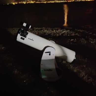 mit Teleskop am Strand die Saturnringe beobachtet, HELMSail yachting